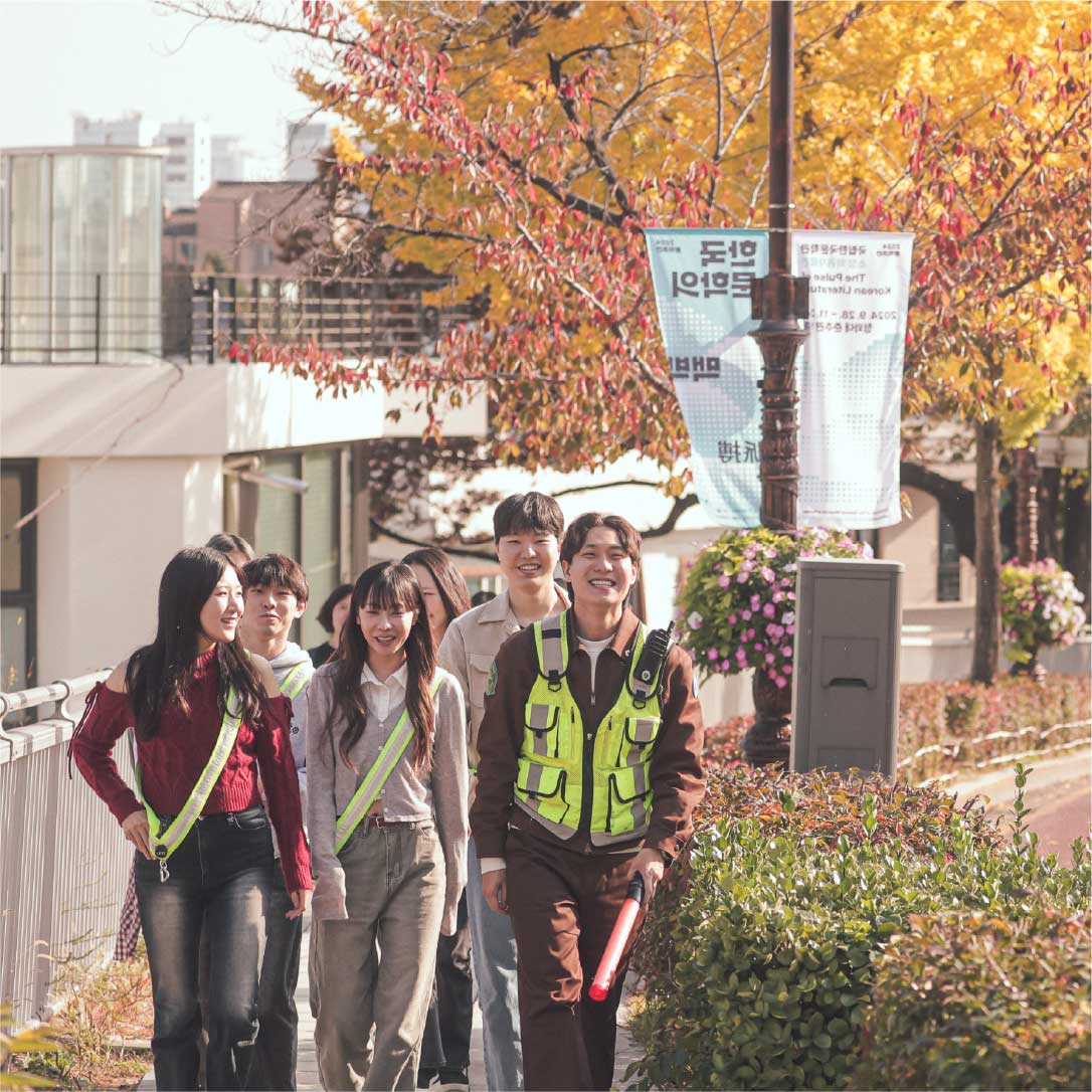 Seoul Tram guide leading a walking group tour under fall foliage 首尔电车导览员带领游客在秋叶中漫步