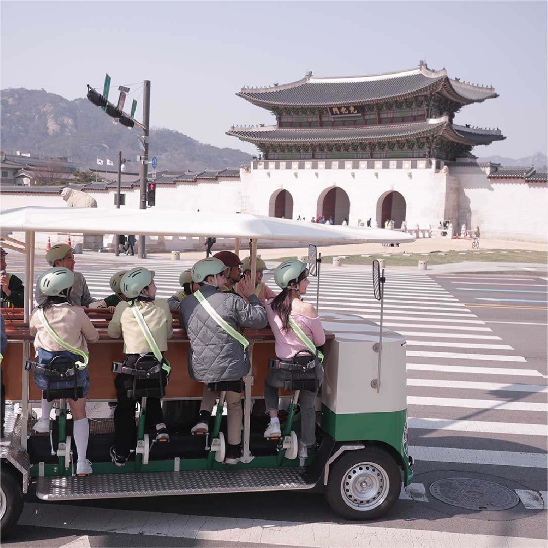 Seoul pedal-powered tram with tourists riding near Gwanghwamun Gate 首尔脚踏电车载游客经过光化门景点